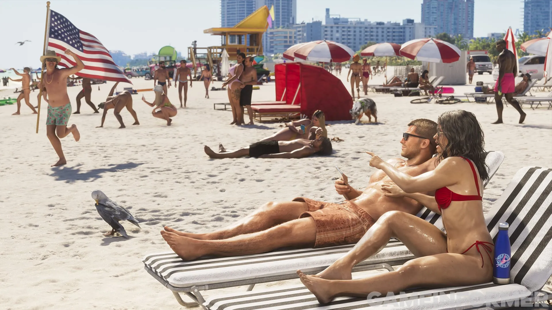 Ein voller Strand in Vice City mit einem Paar auf Liegen, roten Sonnenschirmen, einem Rettungsturm und einem Mann, der eine amerikanische Flagge schwenkt.