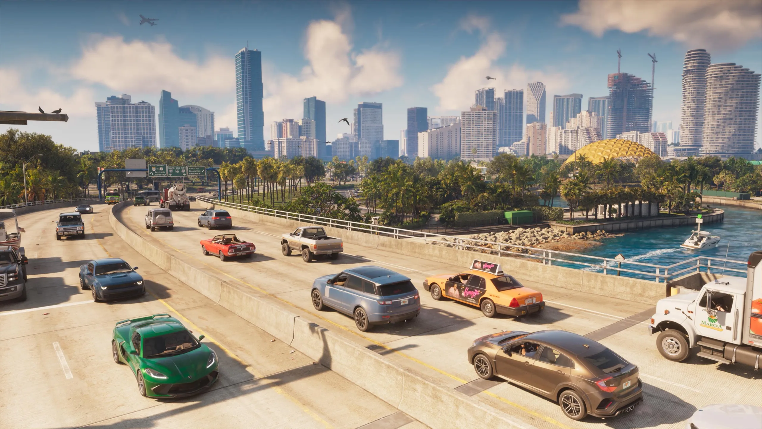 A freeway with traffic in both directions, among them a green sports car, a red convertible and a taxi with an advert on its roof, in front of palm trees and a skyline of towers.